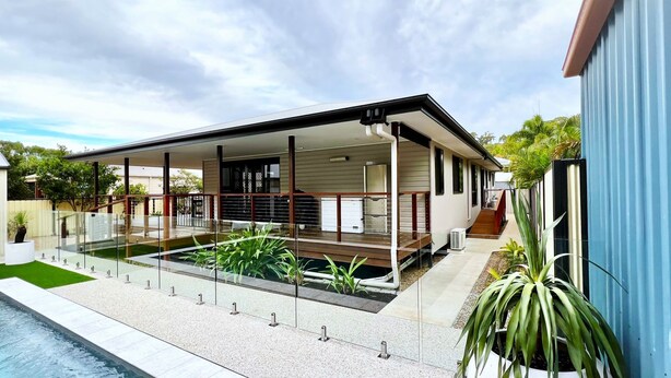 Una casa moderna con piscina, un patio cubierto y jardín.