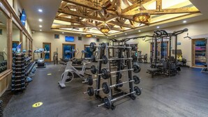 A spacious gym with ceiling beams, various exercise equipment, and a large mirror. - Spacious 4 bedroom 3.5 bath with a great view from building two second level. (Cabo San Lucas)