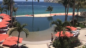 A resort pool area with palm trees, a view of the ocean, and a beach. - Spacious 4 bedroom 3.5 bath with a great view from building two second level. (Cabo San Lucas)