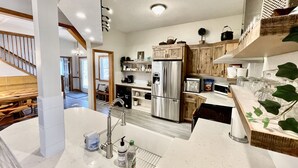Une cuisine moderne dotée d’appareils électroménagers en acier inoxydable, de meubles en bois et d’un plan de travail en marbre.