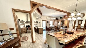 Une cuisine spacieuse dotée d’un grand îlot central, de meubles en bois et d’un coin repas avec une table et des chaises en bois.