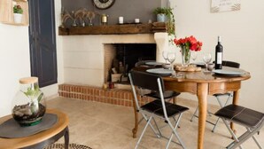 A dining area with a wooden table, black chairs, and a fireplace.