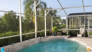 Una piscina interior con agua azul cristalina, rodeada por un cerramiento de vidrio y equipada con juguetes inflables.