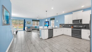 A modern kitchen with white cabinets, a black microwave, and a dishwasher. - 8BR Disney Getaway In Champions Gate! FREE POOL HEAT if you book by May 1st (Davenport)