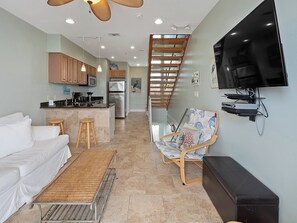 A modern living room with a sofa, a coffee table, a TV, and a chair.