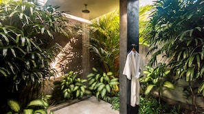 Surrounded by lush greenery, this serene space offers a refreshing spot to unwind with a shower facility nearby.