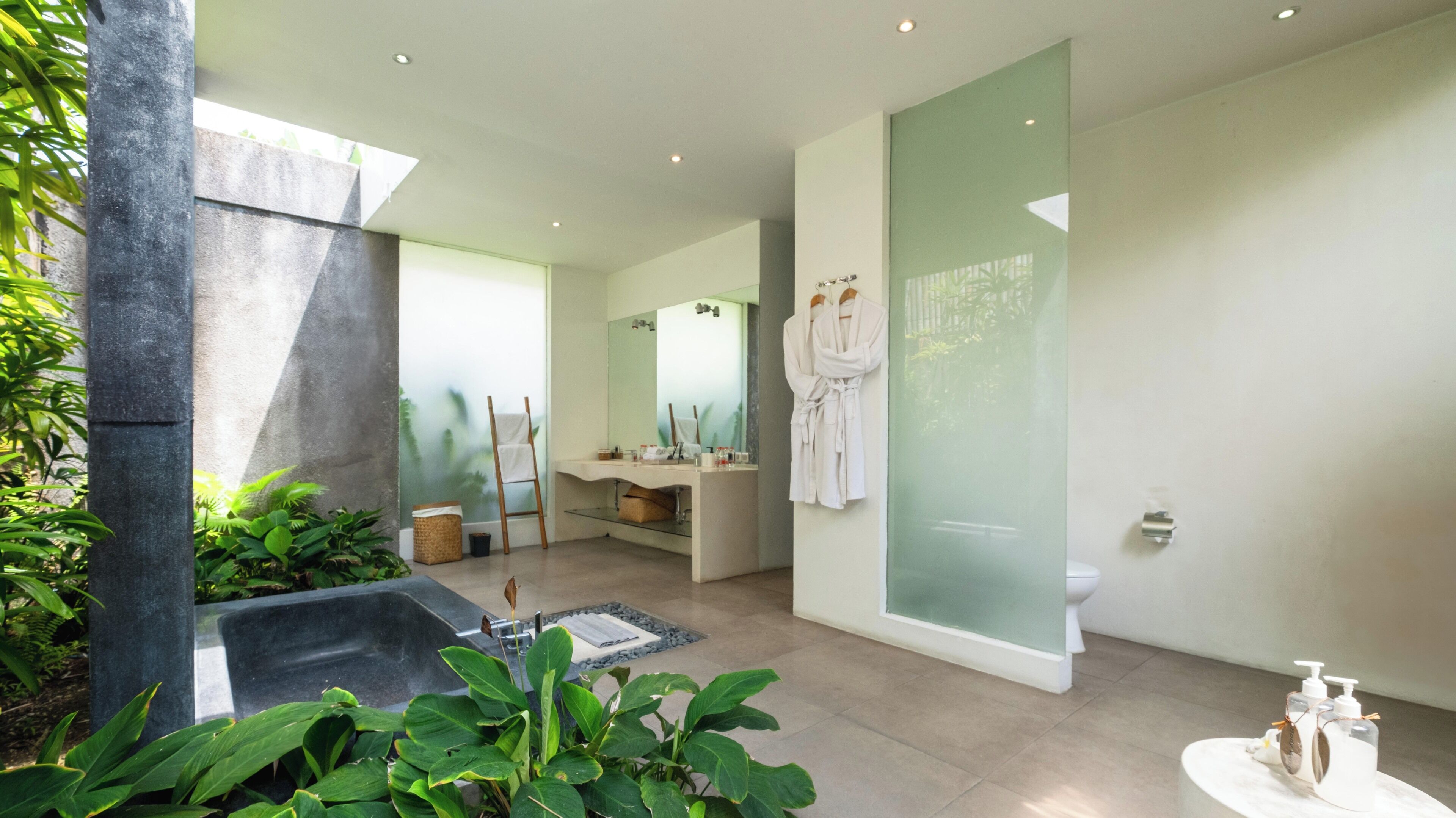 A modern bathroom with a large bathtub, a vanity with a mirror, and a glass shower enclosure.