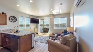 A spacious living area with a kitchen, a large window, and a view of the outdoors.