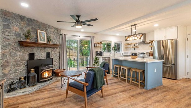 Eine moderne Küche mit Steinwand, Kamin und Essbereich mit Holzmöbeln.
