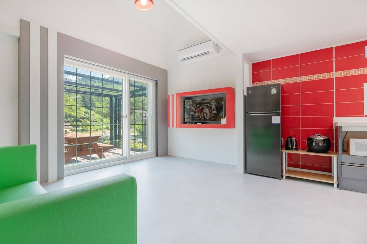 Una cocina moderna con un amplio ventanal corredera que da a un patio, un refrigerador y un microondas.