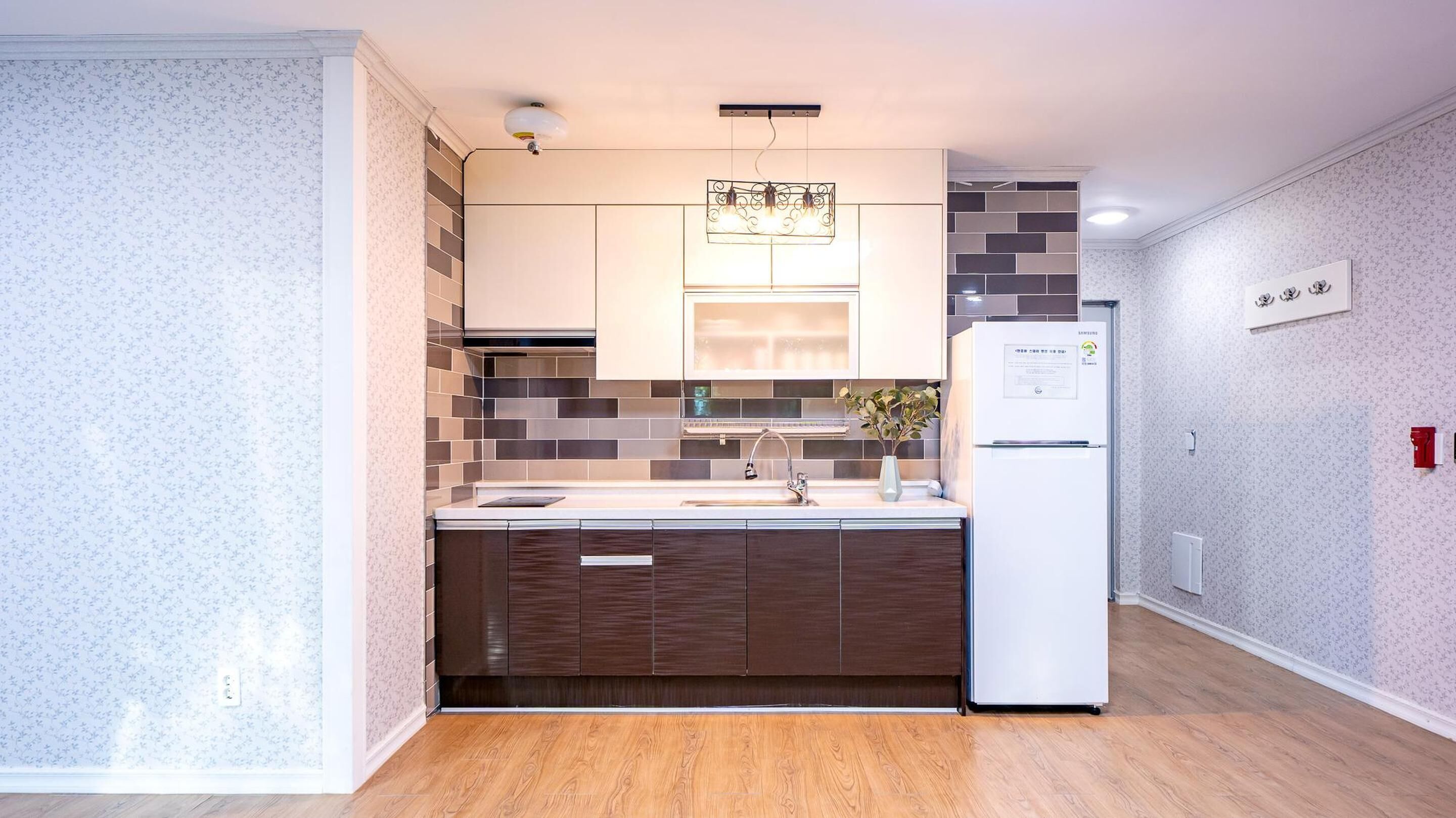 Una cocina moderna con encimera de madera, un lavaplatos empotrado y un refrigerador blanco.