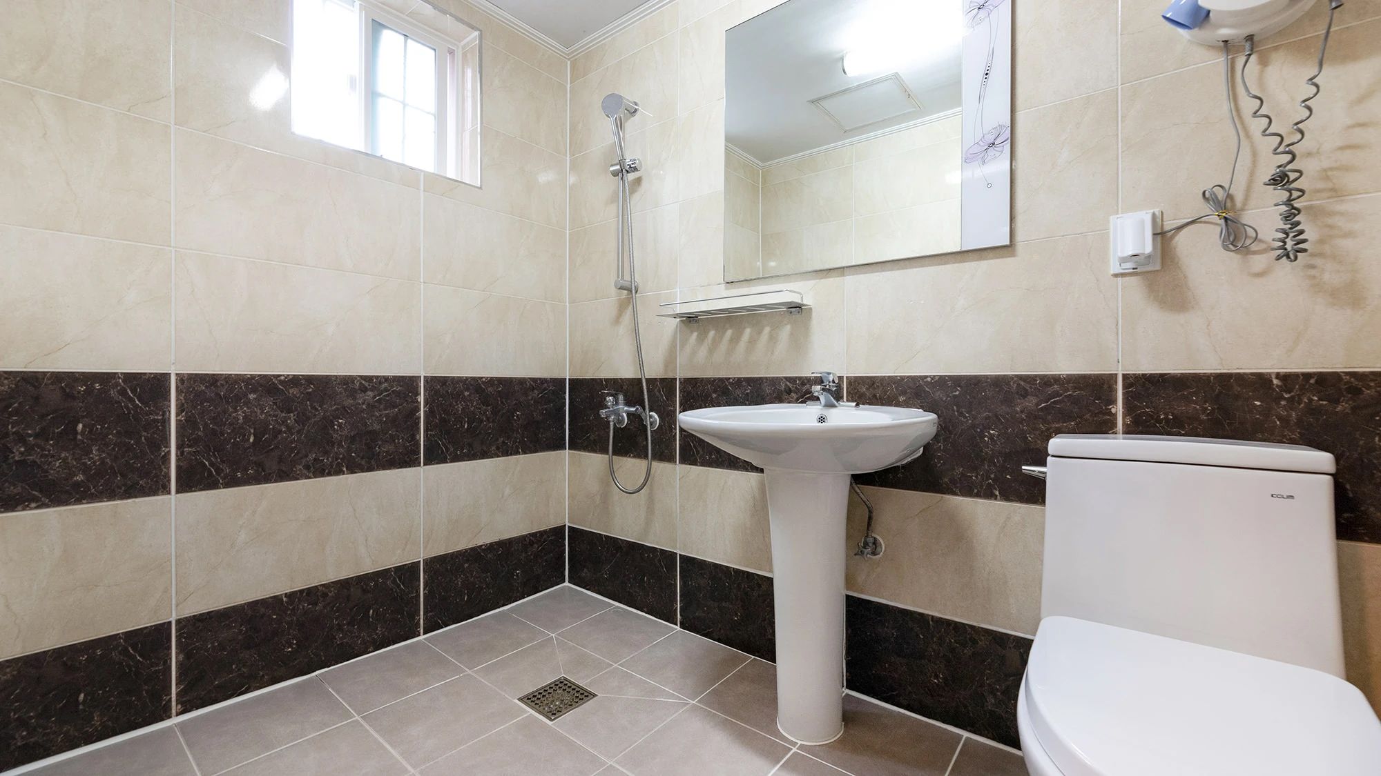 A bathroom with a white sink, a toilet, and a shower.
