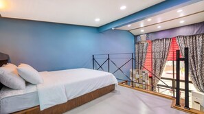 Une chambre à coucher avec un lit, une fenêtre avec des rideaux et une vue sur l’extérieur.