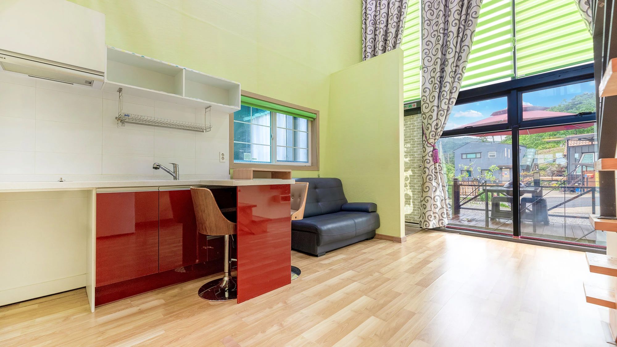 A modern kitchen with a built-in sink and a dining area with a red table and chairs.
