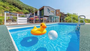 Une piscine avec un flotteur en forme de canard et un grand ballon.