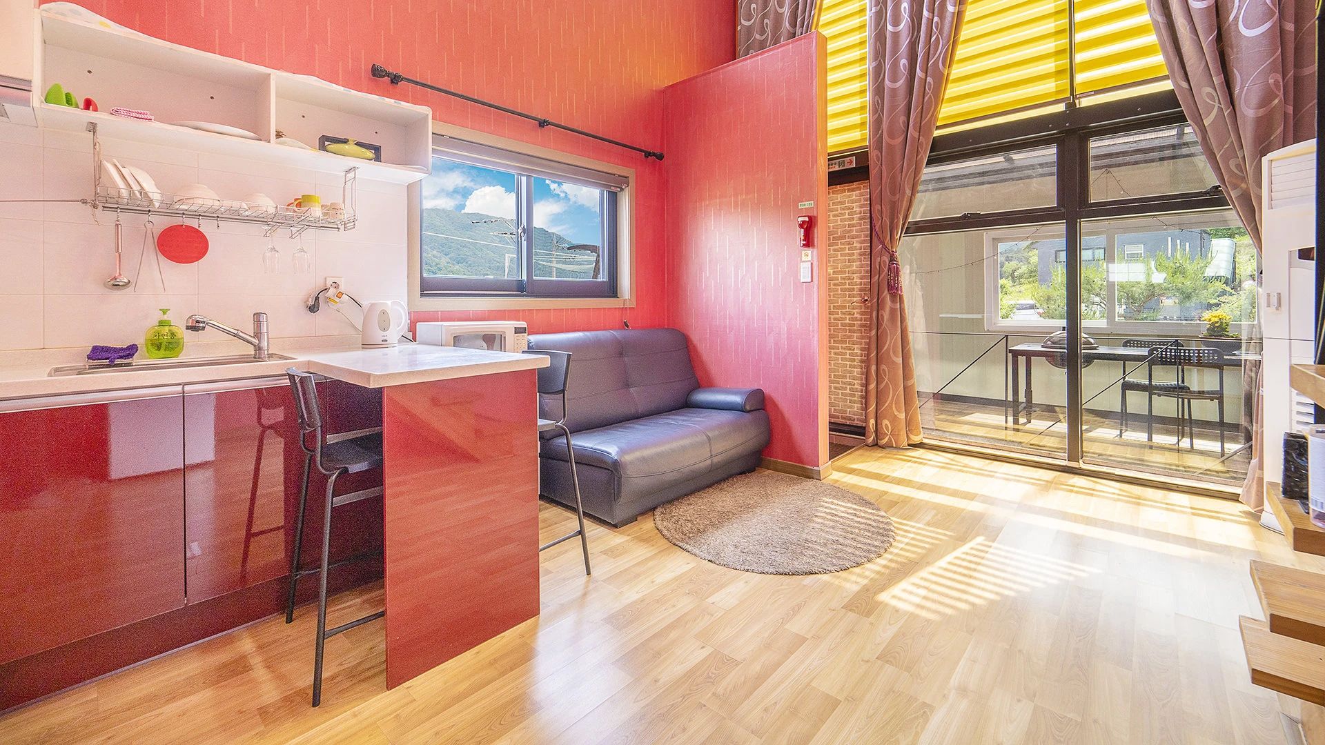 Un espacio habitable funcional con kitchenette, un sofá y una zona de comedor.