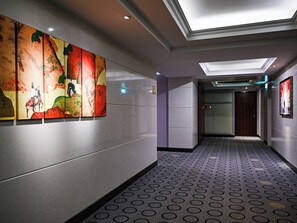 A hallway with patterned flooring, a ceiling light, and a wall with a colorful artwork. - CHECK inn Taipei Neihu (Taipei)