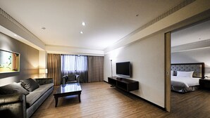 A modern hotel room with a sofa, a coffee table, a TV, and a bed. - CHECK inn Taipei Neihu (Taipei)