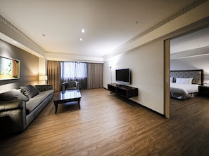 A modern hotel room with a sofa, a coffee table, a TV, and a bed. - CHECK inn Taipei Neihu (Taipei)