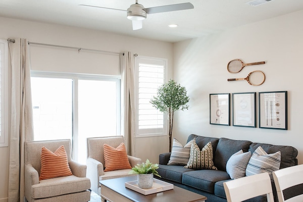 Gather in the bright living room featuring a cozy sectional, stylish decor, and patio access — a perfect home base in Washington, Utah