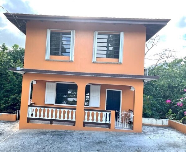 A two-story building with a balcony and a door.