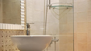 A bathroom with a large white sink, a glass shower enclosure, and tiled walls. - CHECK inn Express Taipei Station (Taipei)