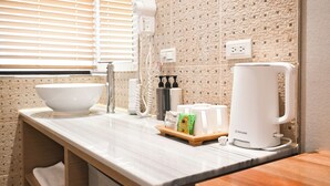 A bathroom with a large white basin, a coffee maker, and toiletries on the counter. - CHECK inn Express Taipei Station (Taipei)