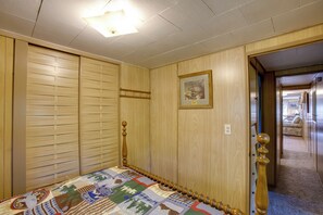 Une chambre à coucher avec une tête de lit en bois, une courtepointe et un tableau encadré accroché au mur.