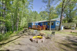 Une cabane dotée d’une terrasse, d’un foyer extérieur et de sièges pour profiter de l’extérieur.