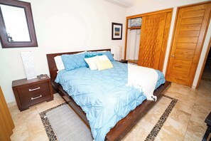 Ein Schlafzimmer mit einem Bett, einem Nachttisch aus Holz und einem Kleiderschrank.