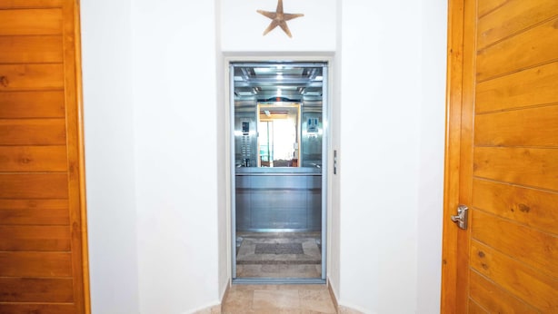 A hallway with wooden doors, a star decoration, and an elevator. - Beachfront Luxury at Tessoro | 3BR Sleeps 8 | Pool (Puerto Peñasco)