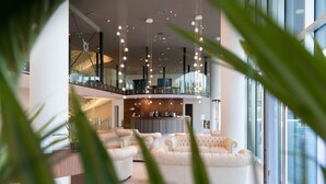 Um hall amplo com teto alto, iluminação moderna e um balcão de recepção.