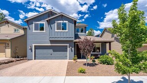 A two-story house with a garage, a driveway, and a small tree in the front yard. - Pico in the Pines, pet friendly and cozy fireplace (Flagstaff)
