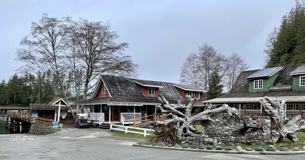 A rustic building with a porch, a stone wall, and a sign that reads 'TELEGRAPH COVE RESORT OFFICE.'