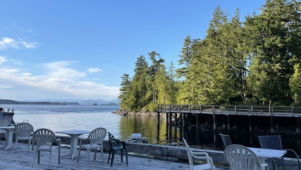 A waterfront patio with outdoor seating and a view of the water.
