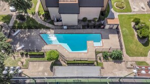Vista aérea de una zona residencial con piscina, terraza cubierta y césped bien cuidado.