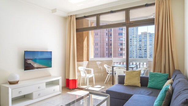 A modern living room with a sofa, TV, and dining area with chairs. - Apartment "Marina Sunny View" with Wi-Fi, Garden & Terrace (Fuengirola)
