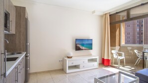 A modern kitchen with a microwave, cabinets, and a dining area with a table and chairs. - Apartment "Marina Sunny View" with Wi-Fi, Garden & Terrace (Fuengirola)