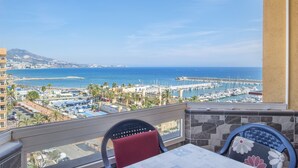 A balcony with a view of the sea, a marina, and buildings in the distance. - Apartment "Stunning Marina View" with Mountain View, Wi-Fi, Garden & Terrace (Fuengirola)