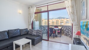 A balcony with a sofa, a table, and a dining area with chairs and a table. - Apartment "Stunning Marina View" with Mountain View, Wi-Fi, Garden & Terrace (Fuengirola)