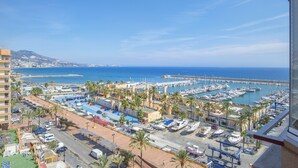 A marina with boats, a road, and buildings with palm trees. - Apartment "Stunning Marina View" with Mountain View, Wi-Fi, Garden & Terrace (Fuengirola)