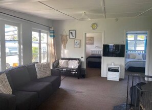 Relax in this spacious living area with a comfortable seating arrangement and large window.