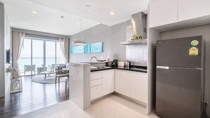 Una cocina moderna con refrigerador empotrado, un comedor con mesa redonda y un ventanal con vistas.