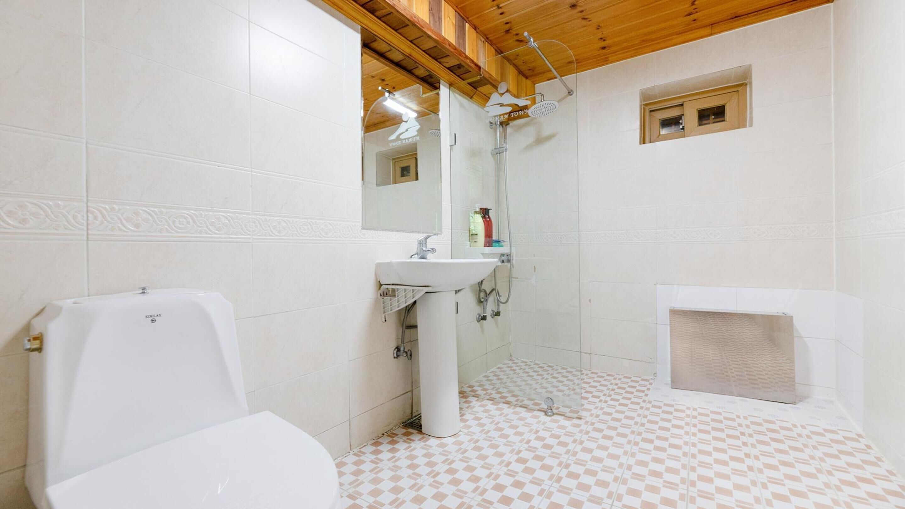 A bathroom with a toilet, sink, and shower.