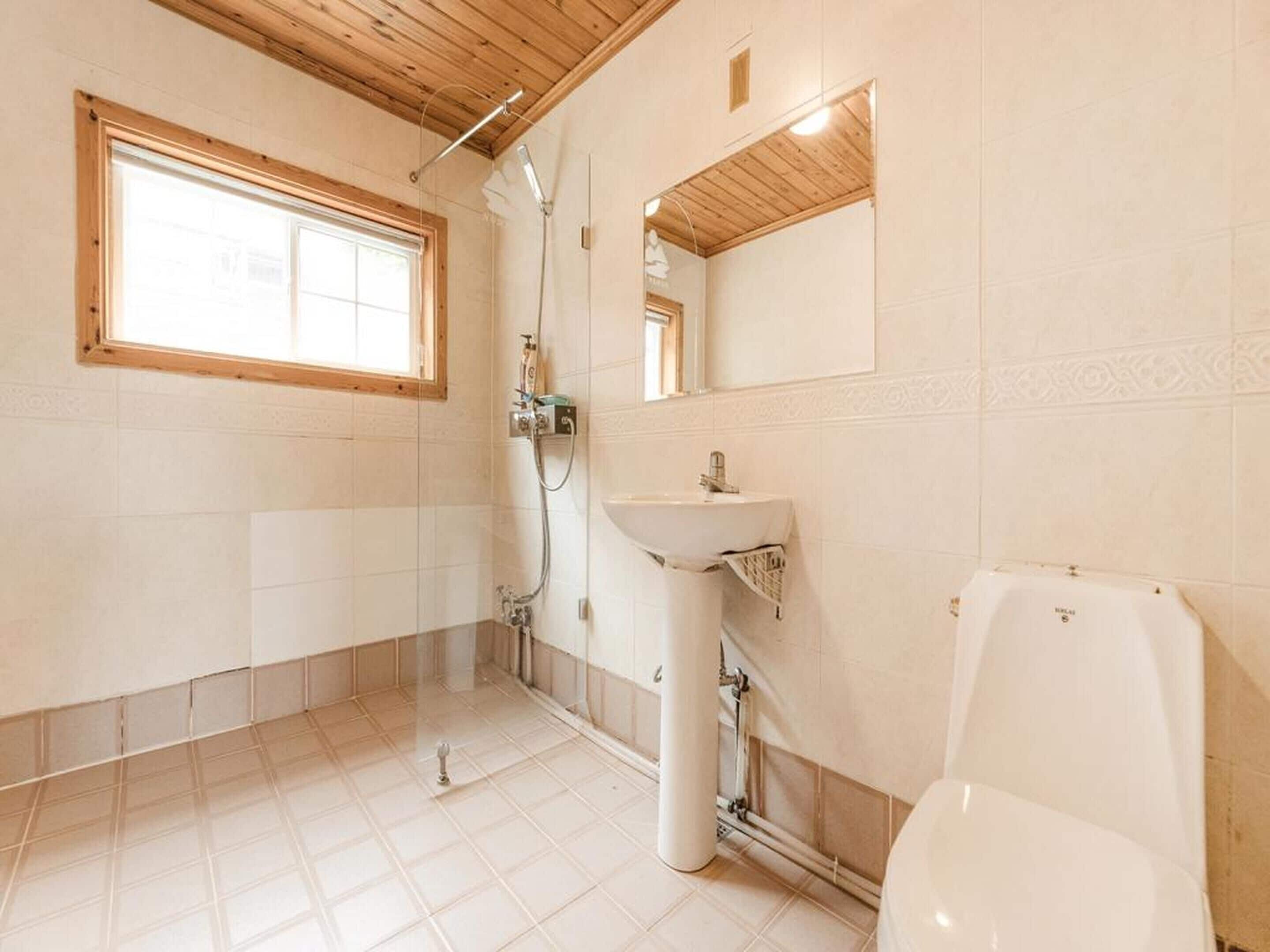 A bathroom with a window, a sink, and a toilet.