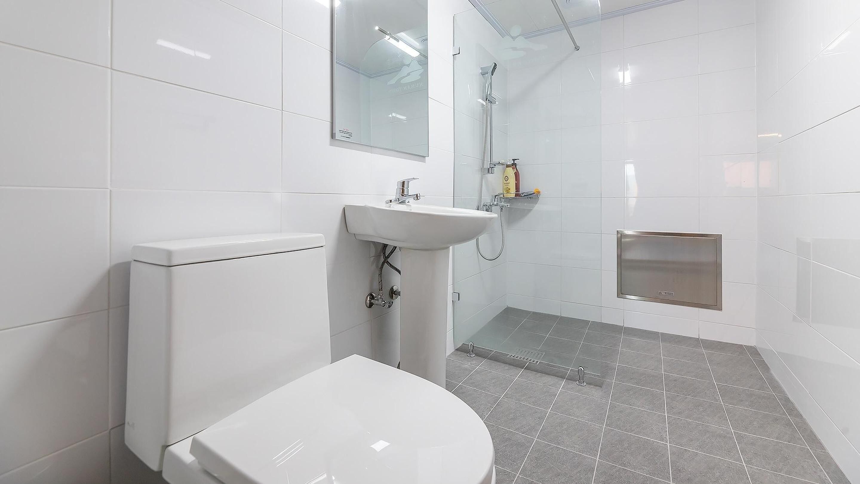 A modern bathroom with a toilet, sink, and shower.