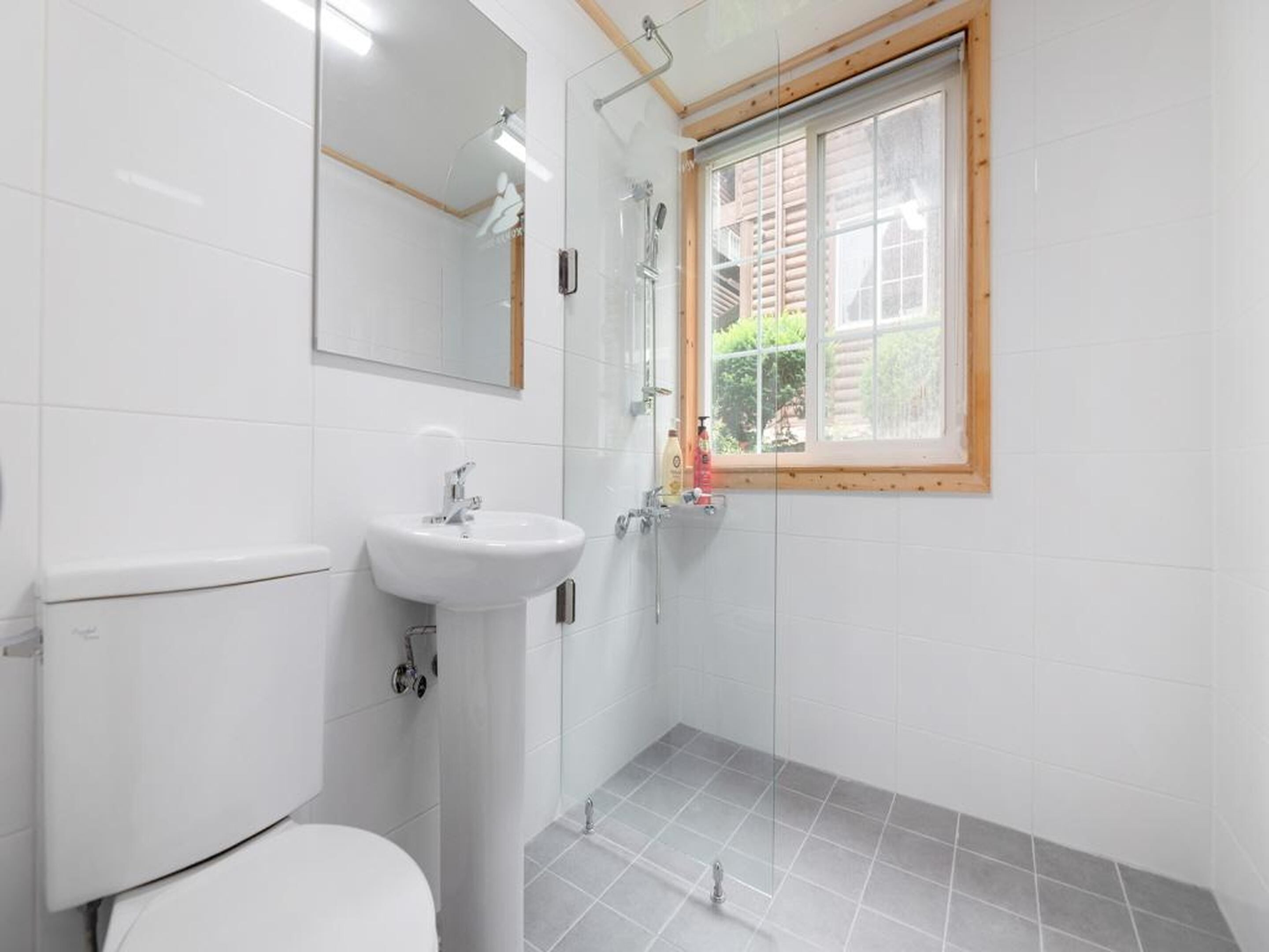 Un baño con inodoro, lavabo y ducha.