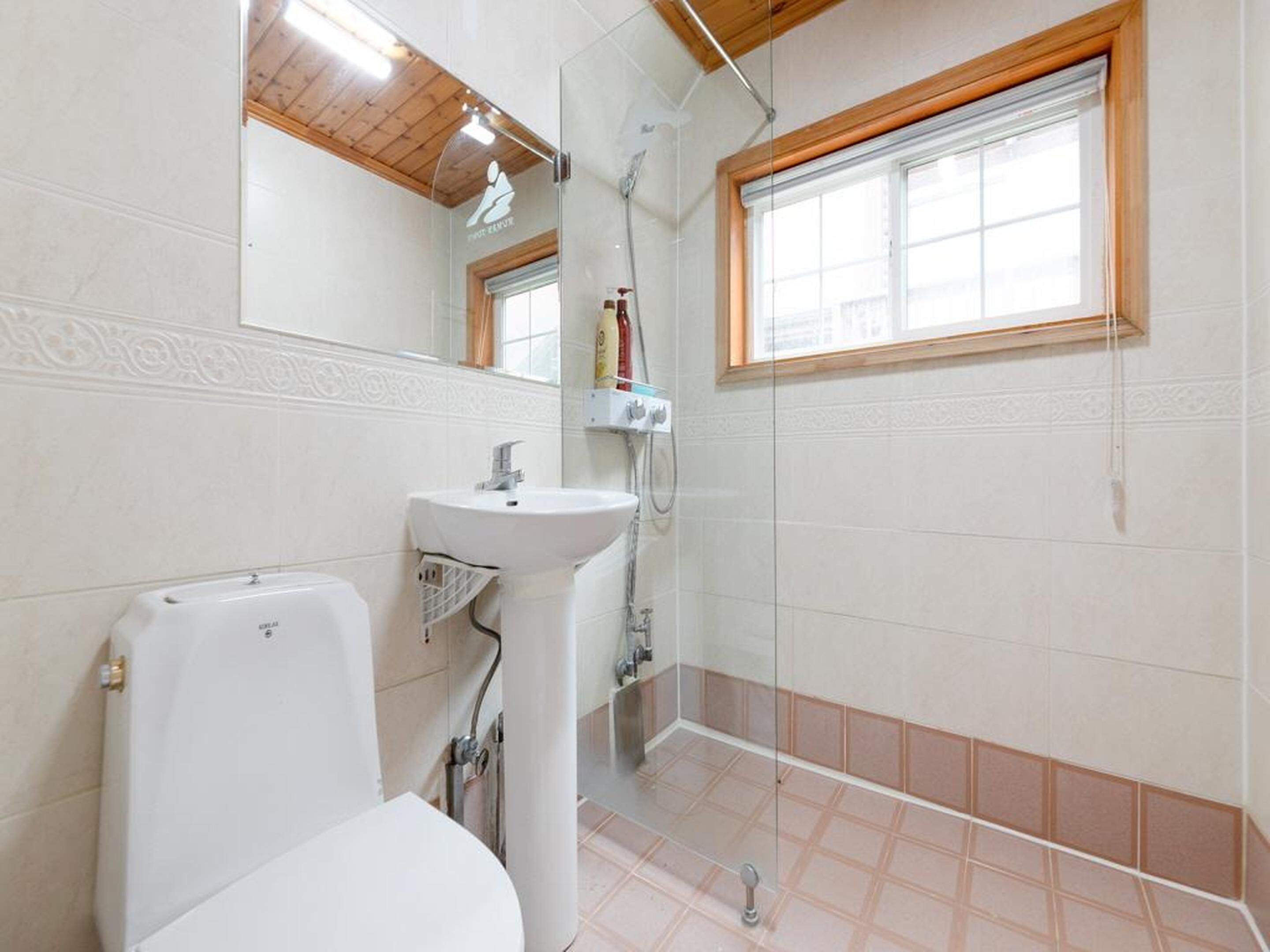 A bathroom with a toilet, sink, and shower.