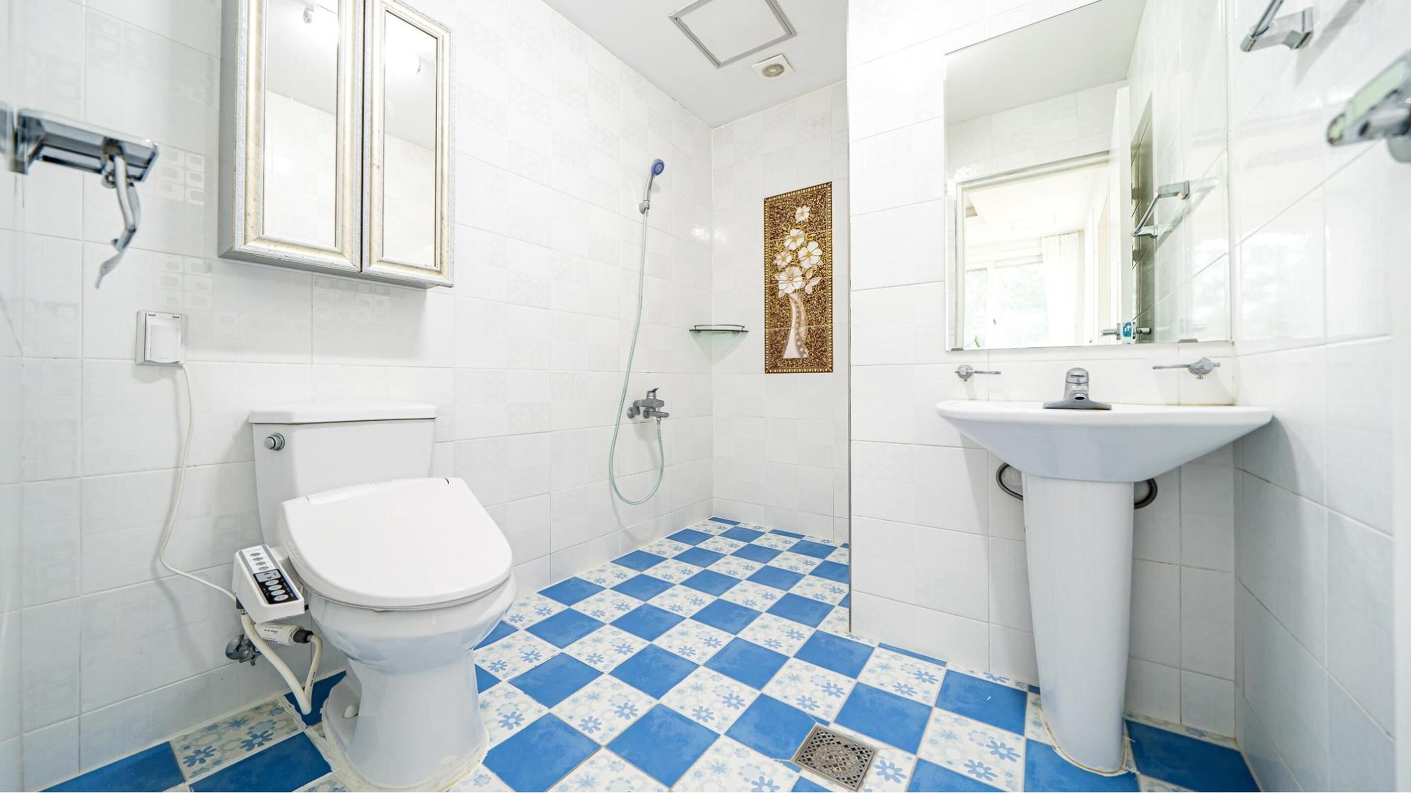 A bathroom with a toilet, shower, and sink.