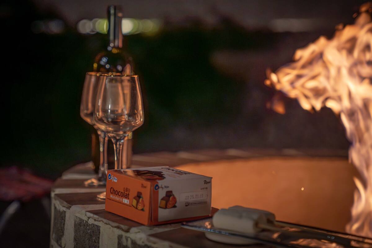 En æske Chocolat Mandarin, en flaske og et glas på et bord.